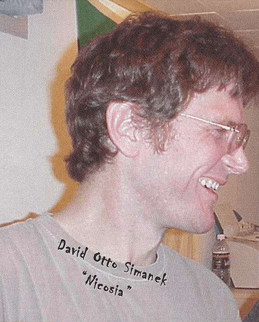 Contemporary image of a smiling middle-aged man in profile. Text on photo says "David Otto Simanek "Nicosia"."