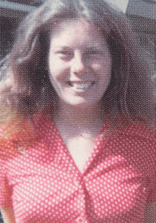Woman in a pink blouse smiling.