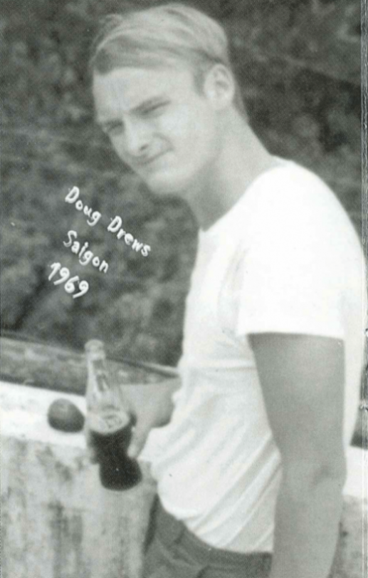Black and white photo of a soldier squinting, holding a Coke; text on photo says "Doug Drews Saigon 1969".