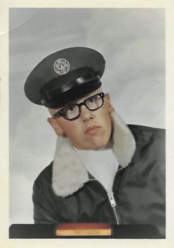 Official military portrait of a young man in glasses, a pilot's cap, and a bomber jacket.