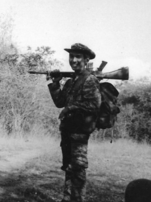 Cambodian soldier with gun over his right shoulder.