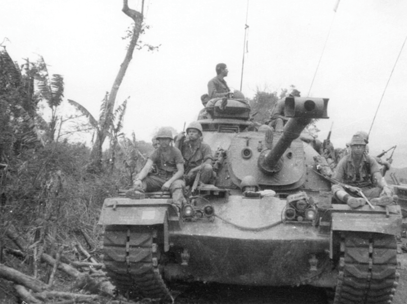 A tank with several men sitting on top of it.