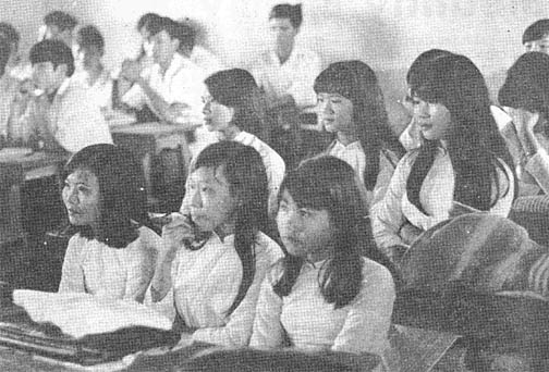 A classroom scene: girls on the right side, boys on the left side, all eyes forward.