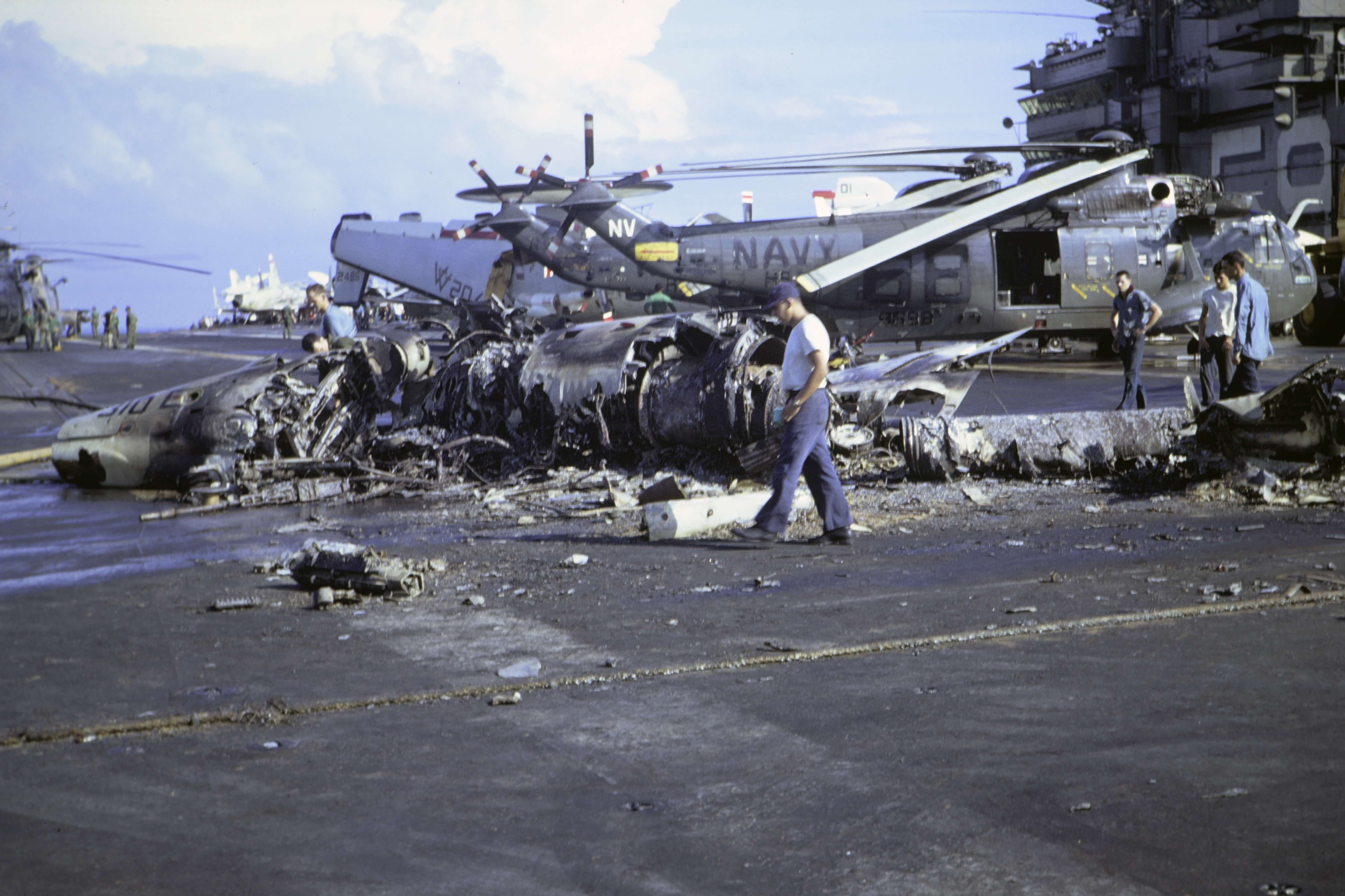 Close up of plane wreckage on top of the deck of a large Navy boat.