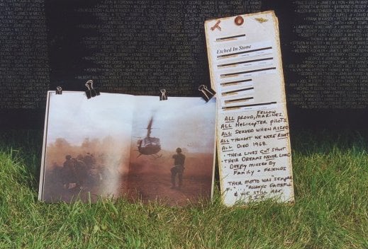 Close up of tributes brought to a scaled-down replica of the Vietnam Wall.