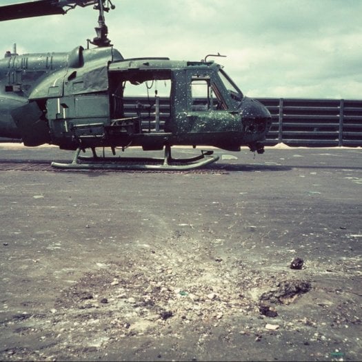An exploded mortar on the ground near a grounded helicopter.