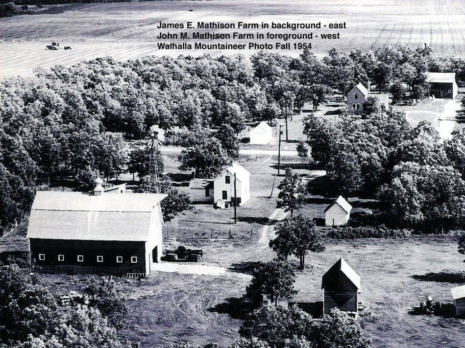 Aerial view of farm lands. Text on photo reads: "James E. Mathison Farm in background - east. John M. Mathison farm in foreground - west. Walhalla Mountaineer Photo Fall 1954."