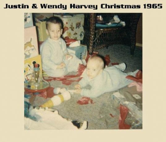 A toddler and an infant in blue pajamas, playing with toys on the floor. Text in photo margins reads: "Justin and Wendy Harvey Christmas 1965".