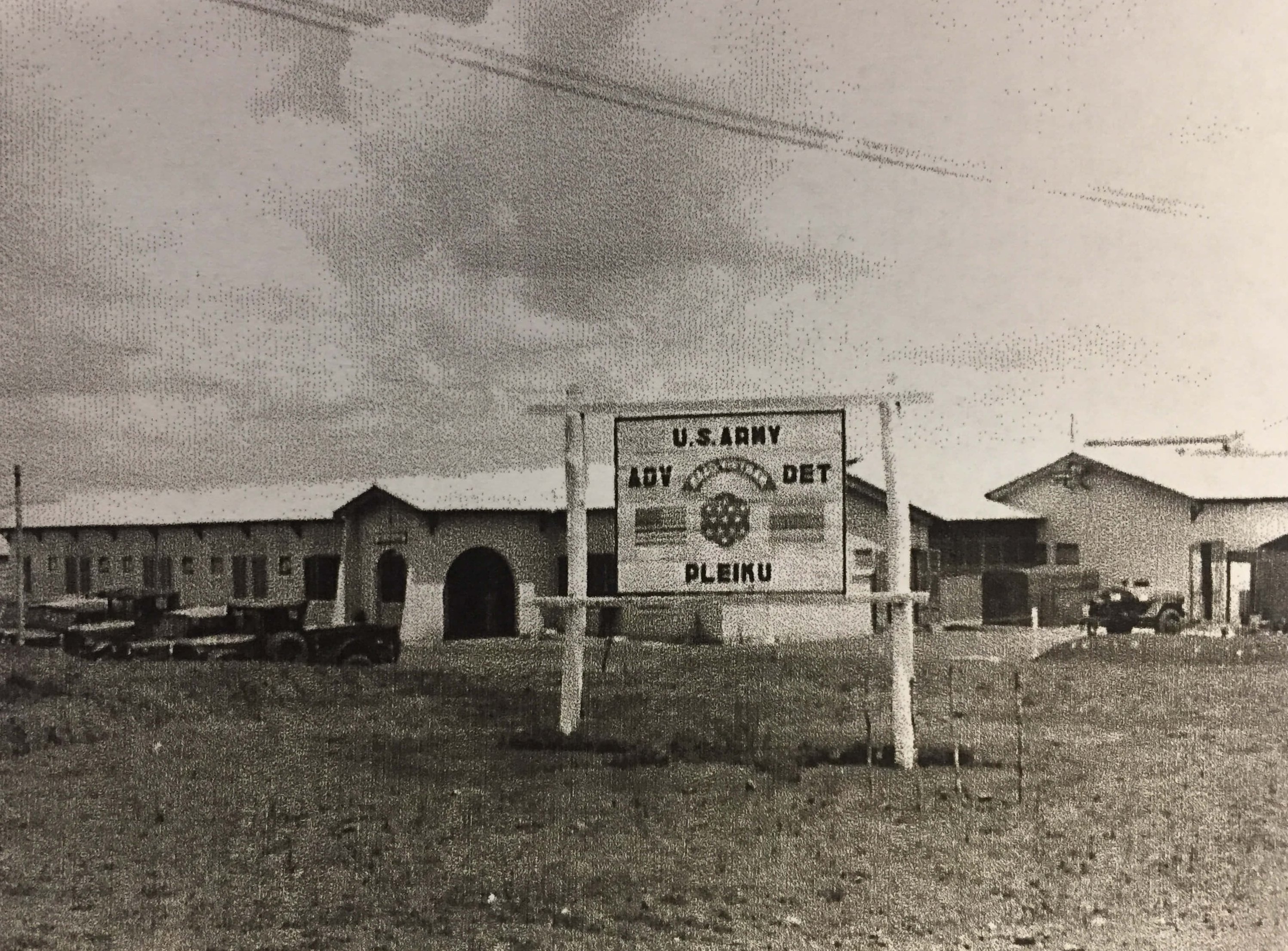 A sign that says "US Army ADV DET Pleiku" in front of some buildings.