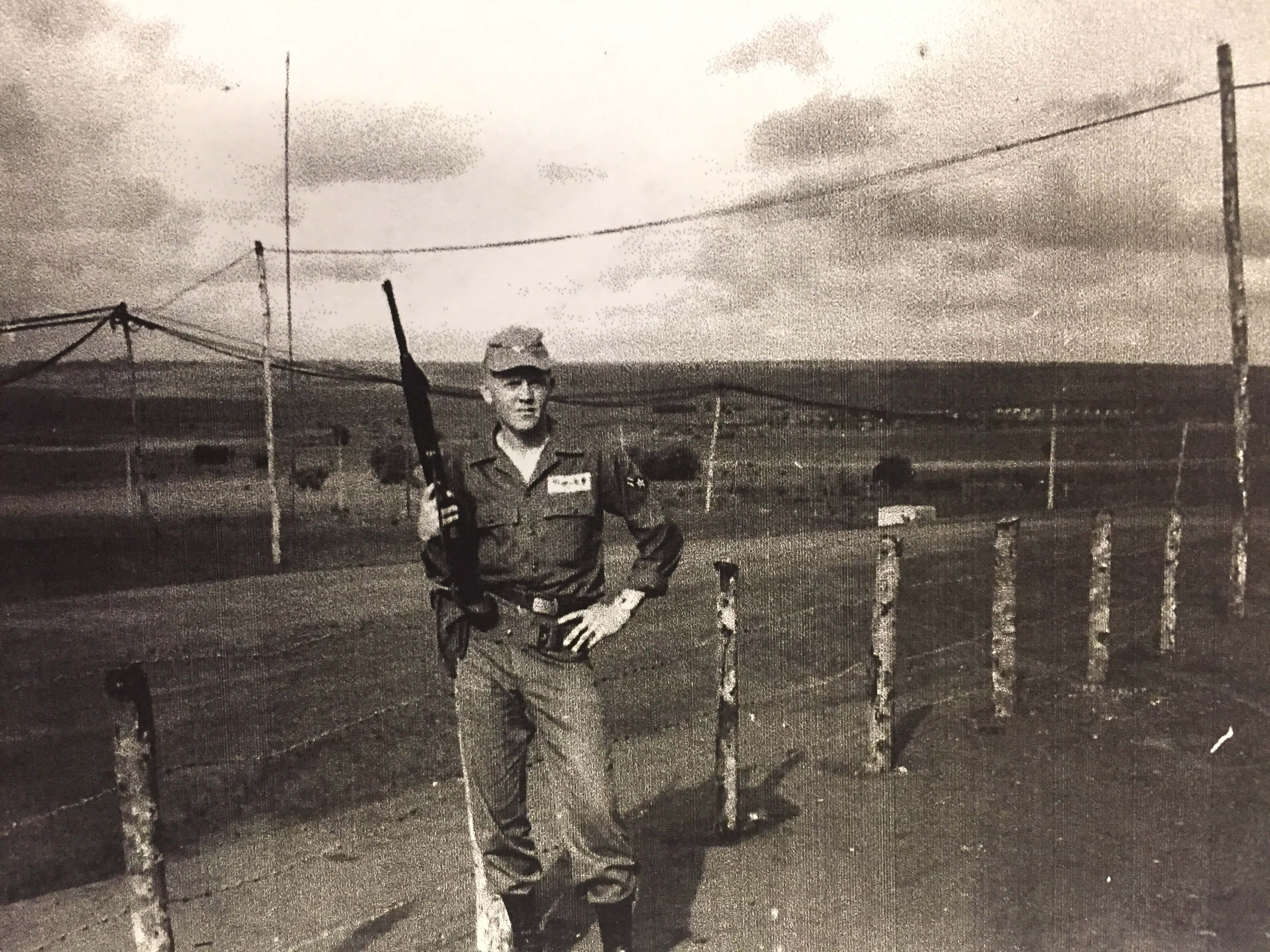 A U.S. soldier with a rifle propped on his right hip, his hand on his left hip.