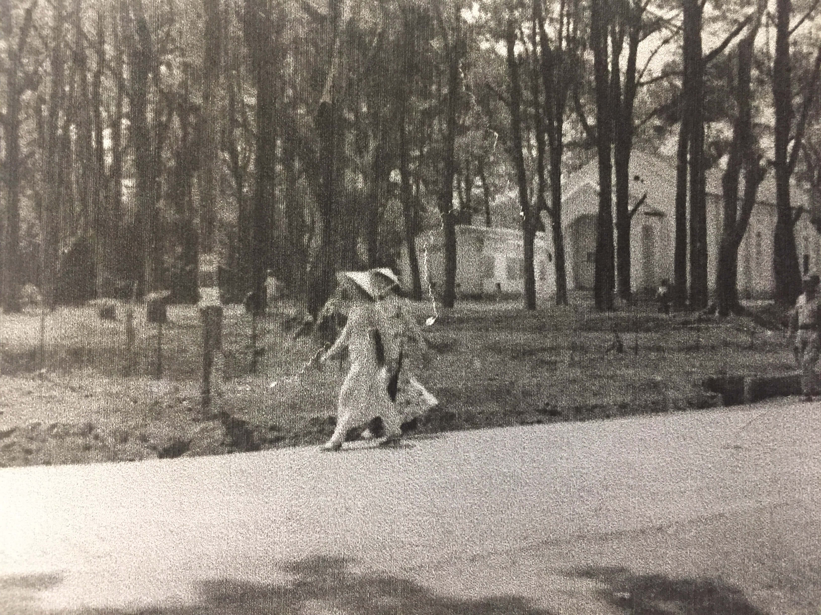 Two women walking along a tree-lined street.