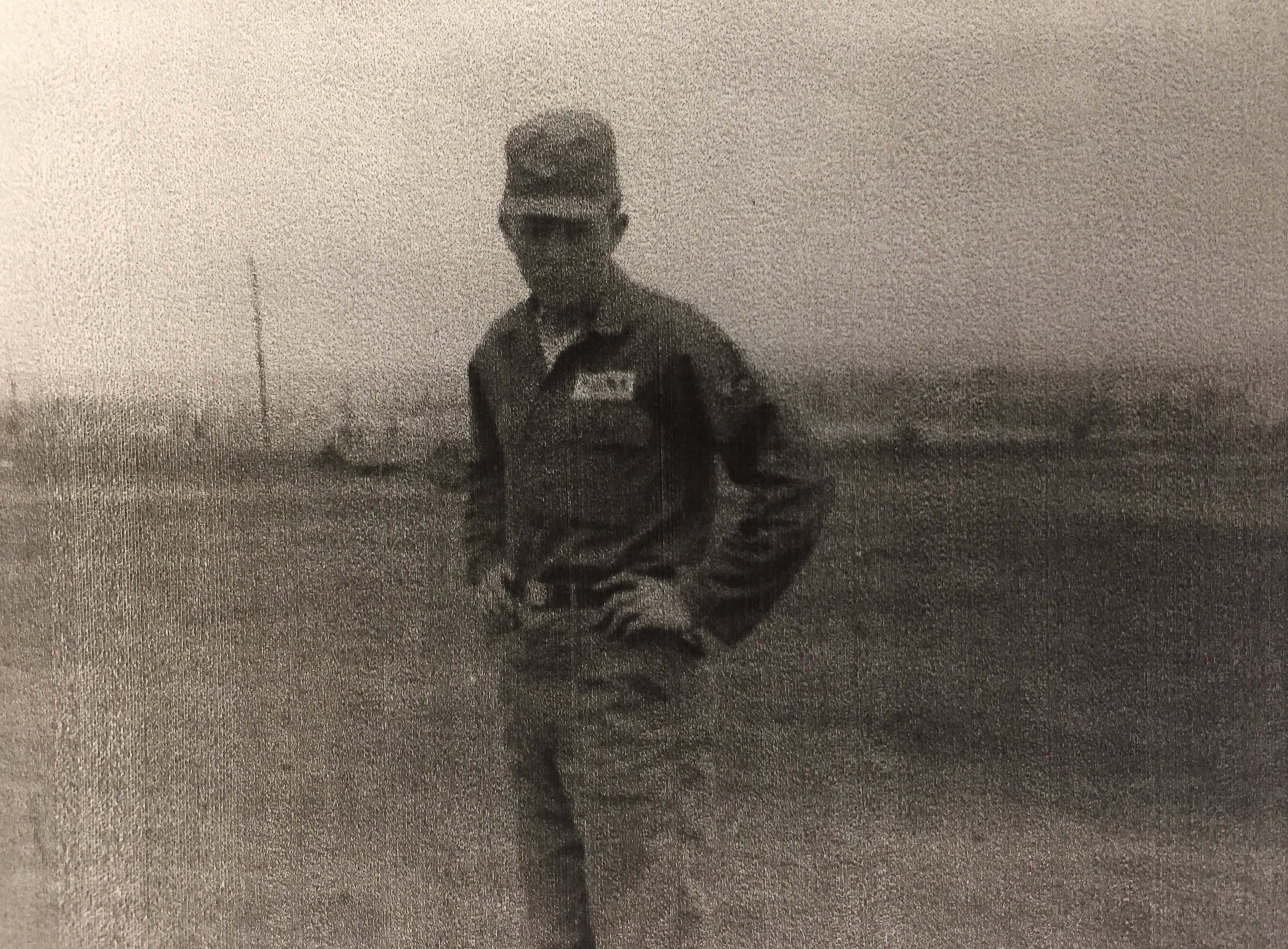 A young man in uniform with hands on his hips.