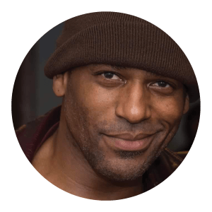 Circular portrait of a smiling African American man.