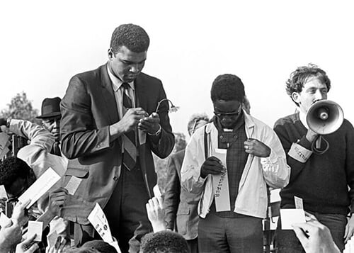 Muhammad Ali signing draft cards.