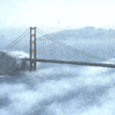 Fuzzy image of a bridge sticking up out of the clouds.
