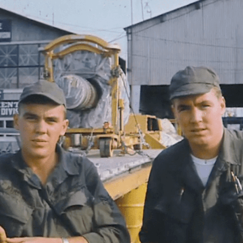 Two young US soldiers who look very similar, standing outside an Air Force base.