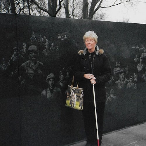 Older woman with cane, standing by the Vietnam War Memorial.