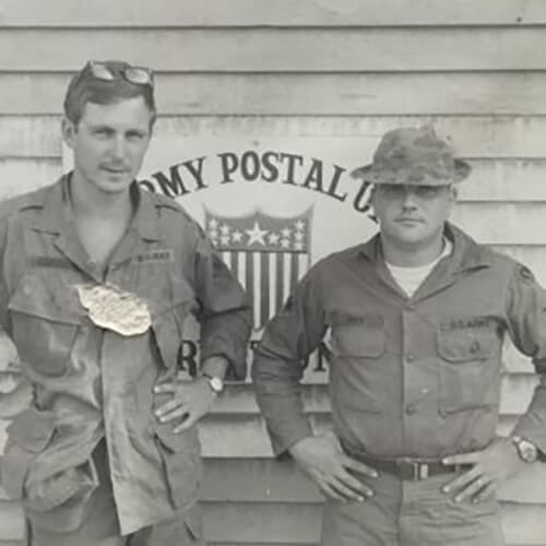 Two young men in uniform, posed with their hands on their hips.