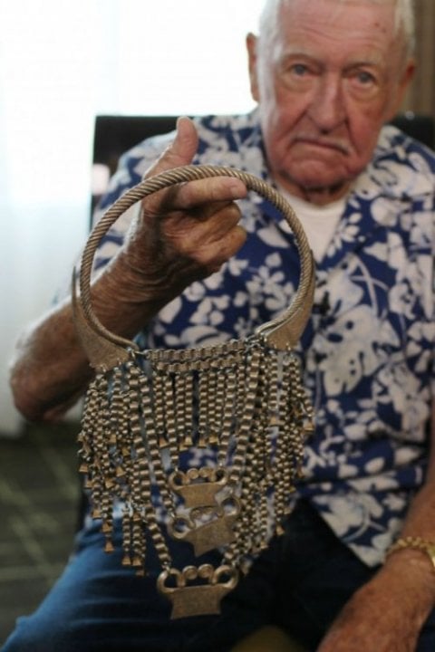 Man holding silver Hmong necklace.