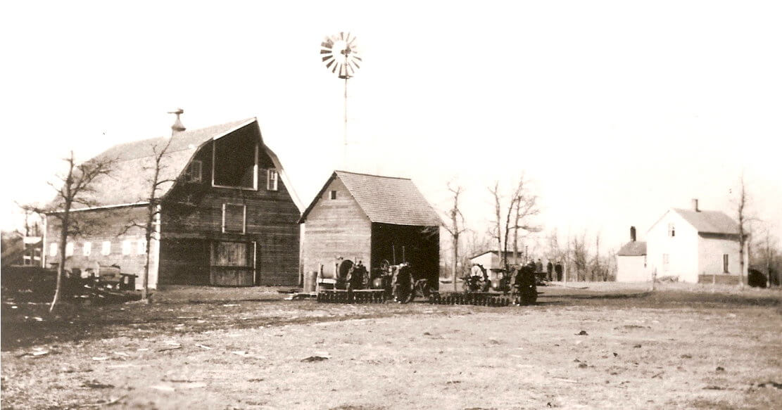 Sepia-toned image of a farmhouse and barn.