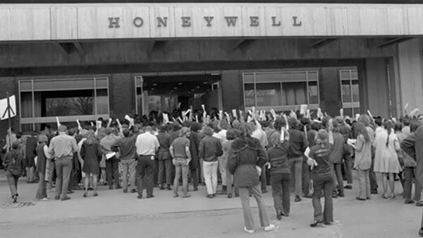 A crowd gathered outside a Honeywell building, their fists raised.