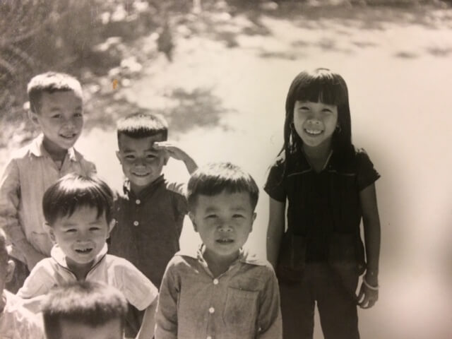 Black and white photo of a group of Vietnamese children in the street.