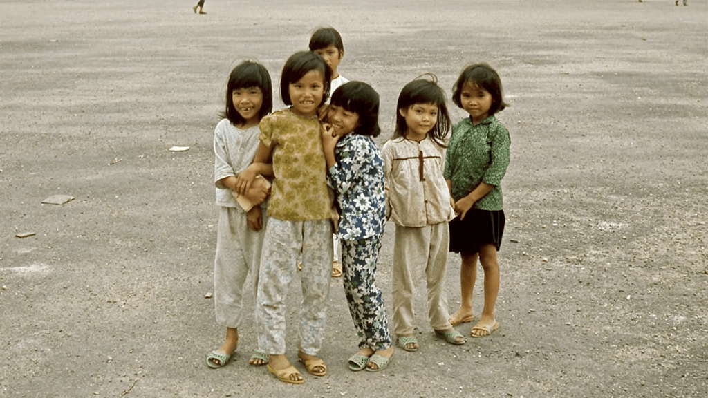 Group of 6 young Asian girls, standing in the street and smiling for the camera.