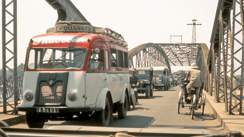 Busses, cars, motorbikes and pedicabs on a bridge.