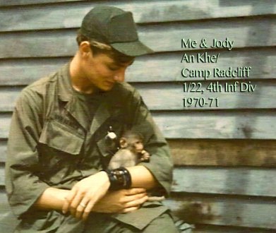 A young soldier holding and looking at a baby monkey. Text on image says "Me & Jody An Khe/Camp Radcliff 1/22 4th Inf Div 1970-71".