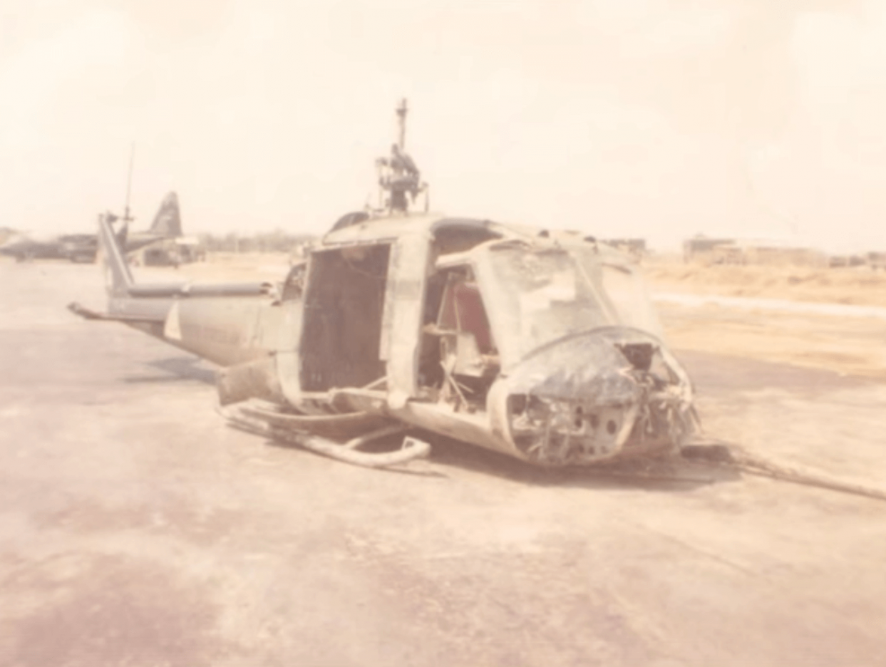 The damaged shell of a helicopter on a tarmac.