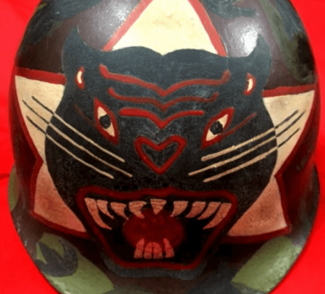 Close up of a helmet with a panther coming out of a white star.