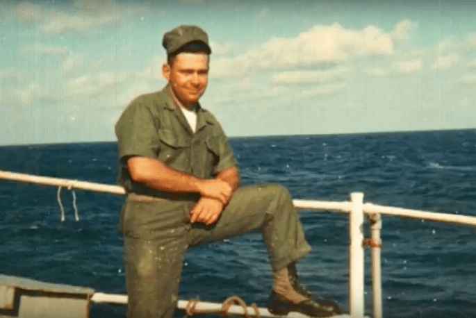 Soldier on a boat in a green uniform.