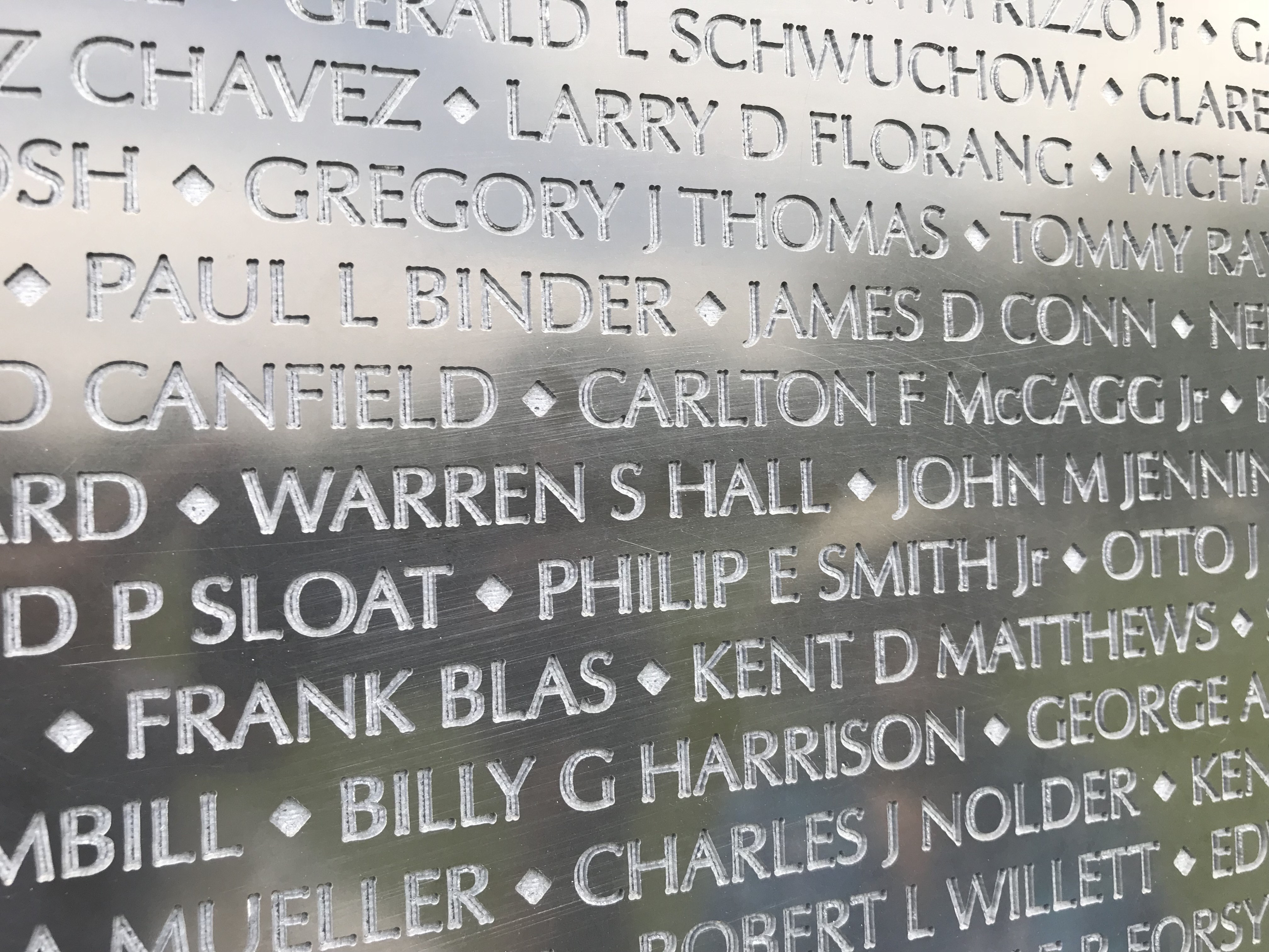 Engraved names in a reflective black memorial wall.