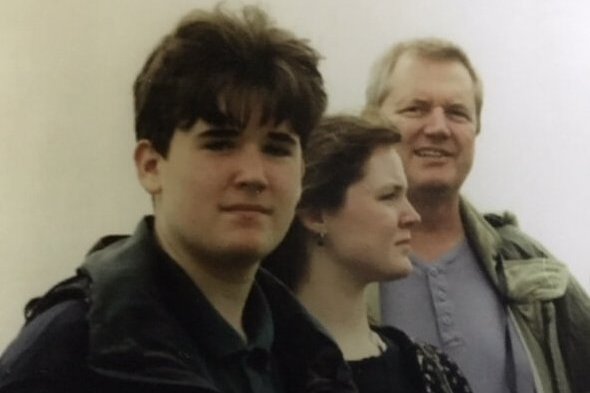 An adolescent boy and girl and their father.