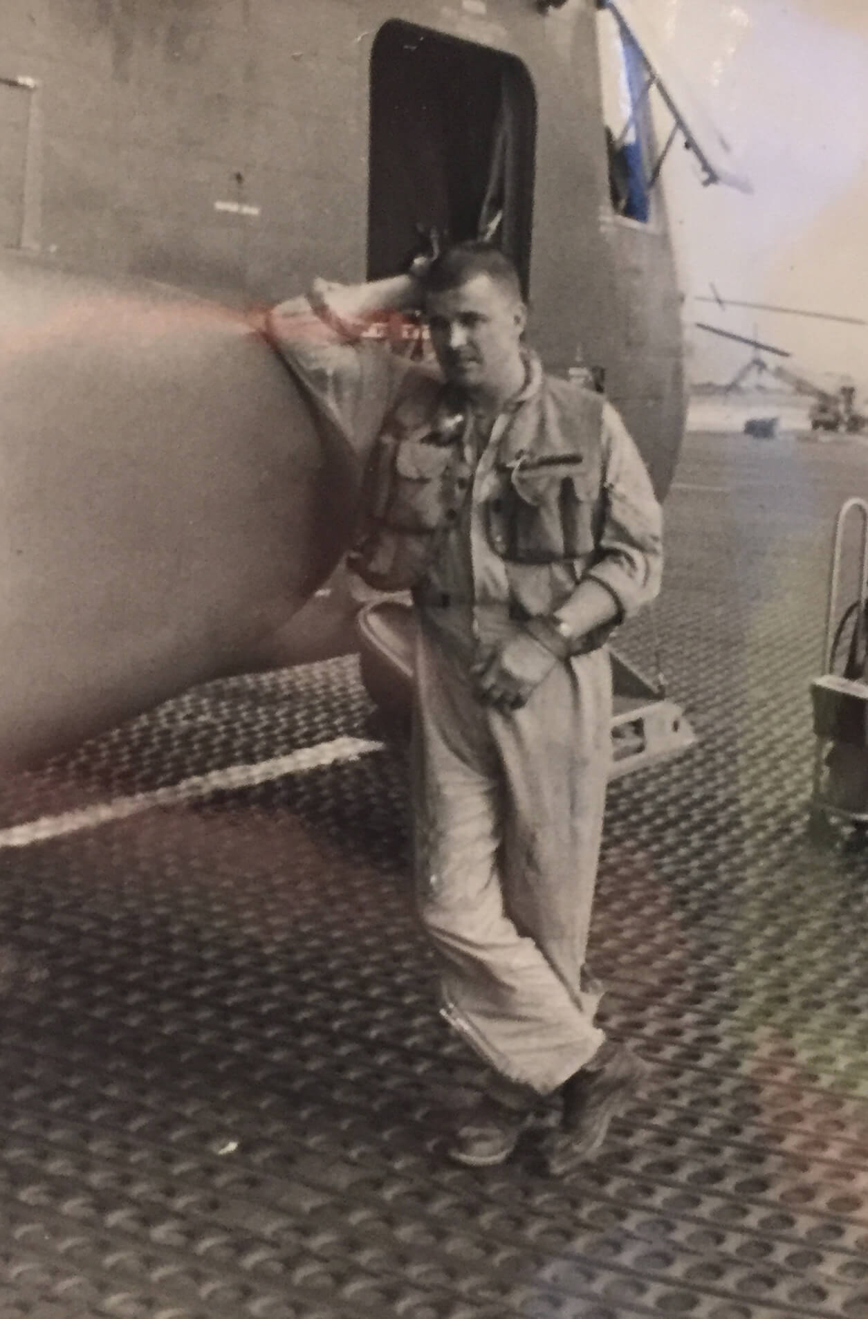 Young soldier leaning up against an airplane