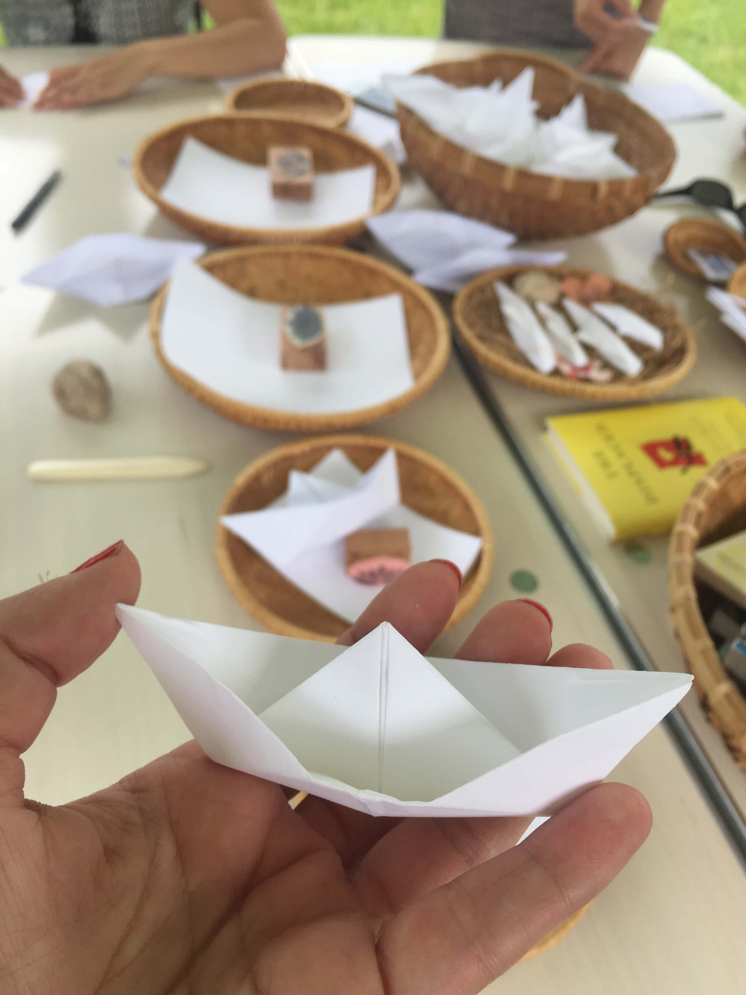 Hand holding a folded paper boat.