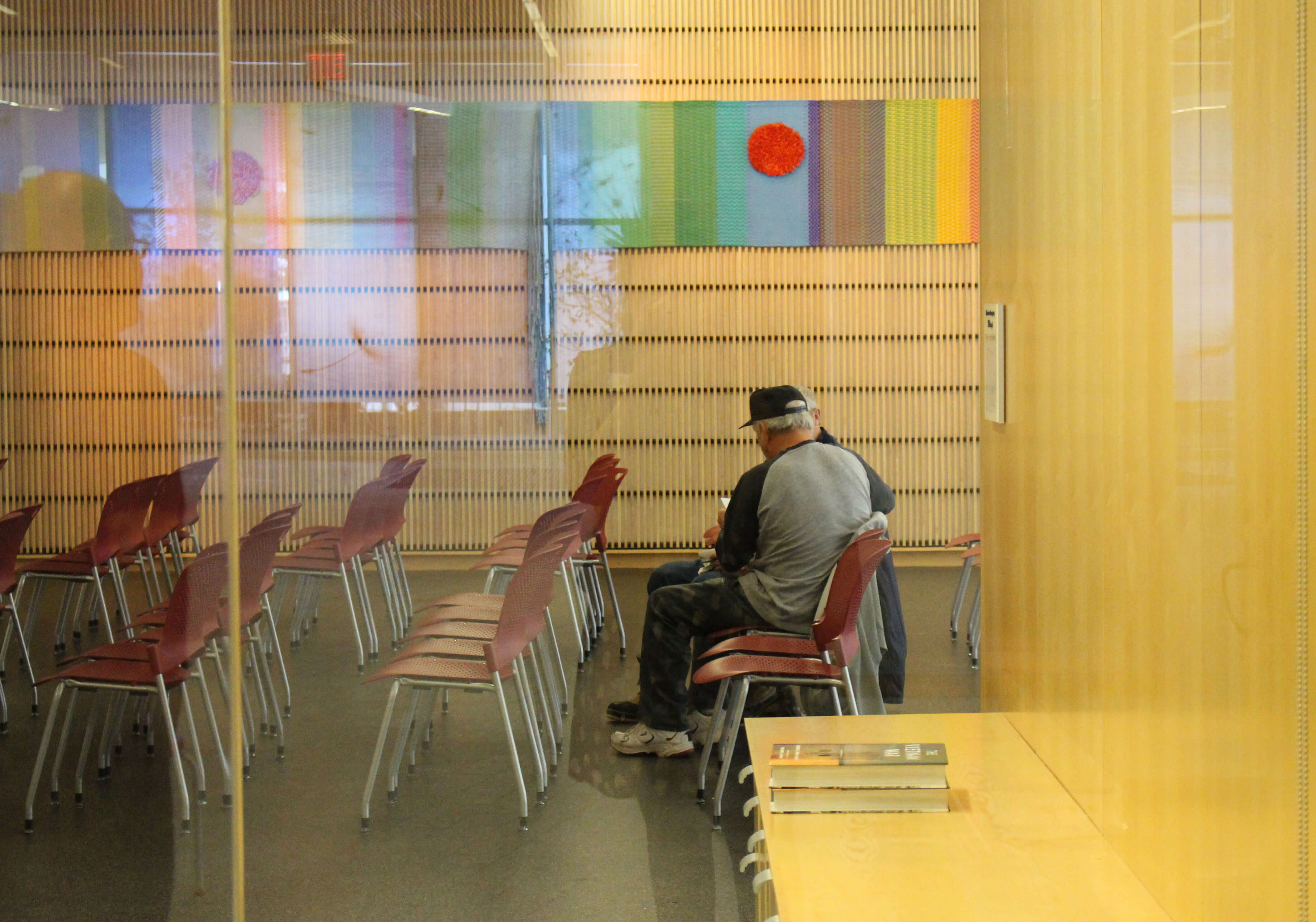Two men talking in chairs at a library.