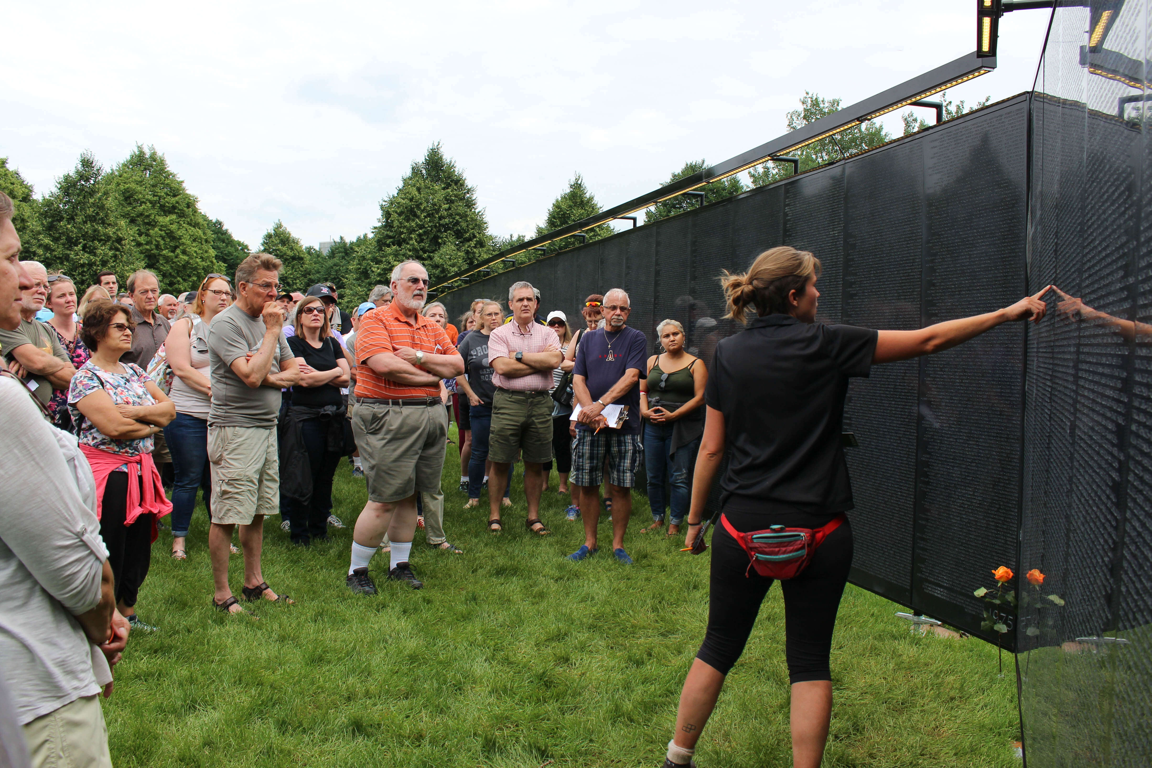Group of volunteers by a replica of the Vietnam Wall.