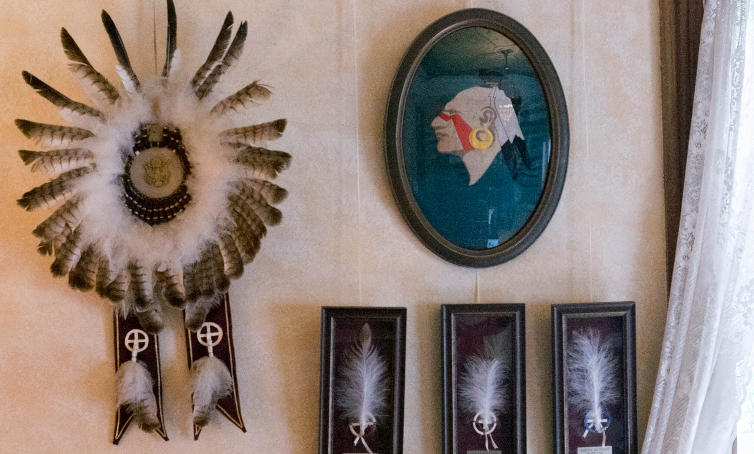 Photos and eagle feathers on a wall