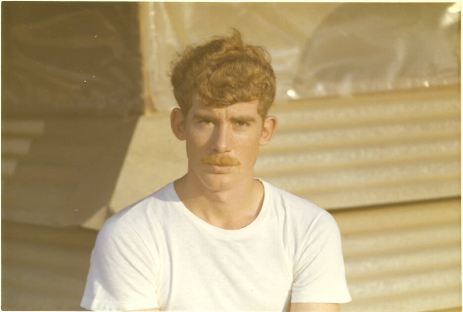 Soldier in a white tee shirt looking at camera