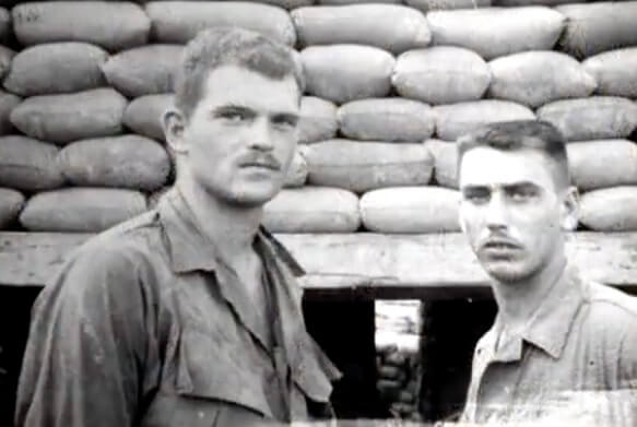 Two soldiers in front of sand bags