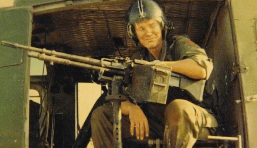 Vietnam soldier with machine gun in helicopter