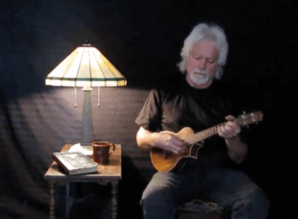 Man in a dark room playing a guitar